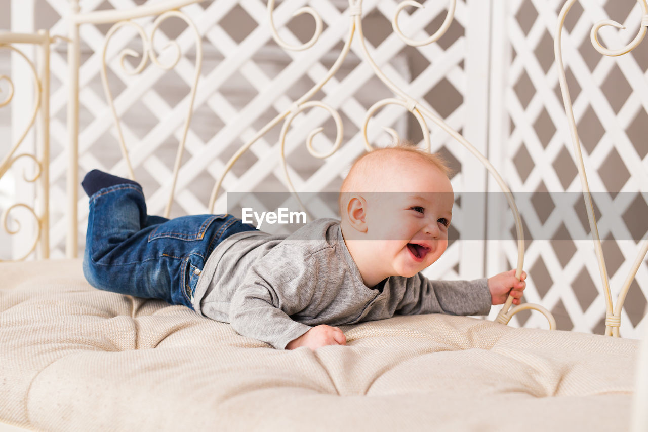 Cute baby lying on bed at home