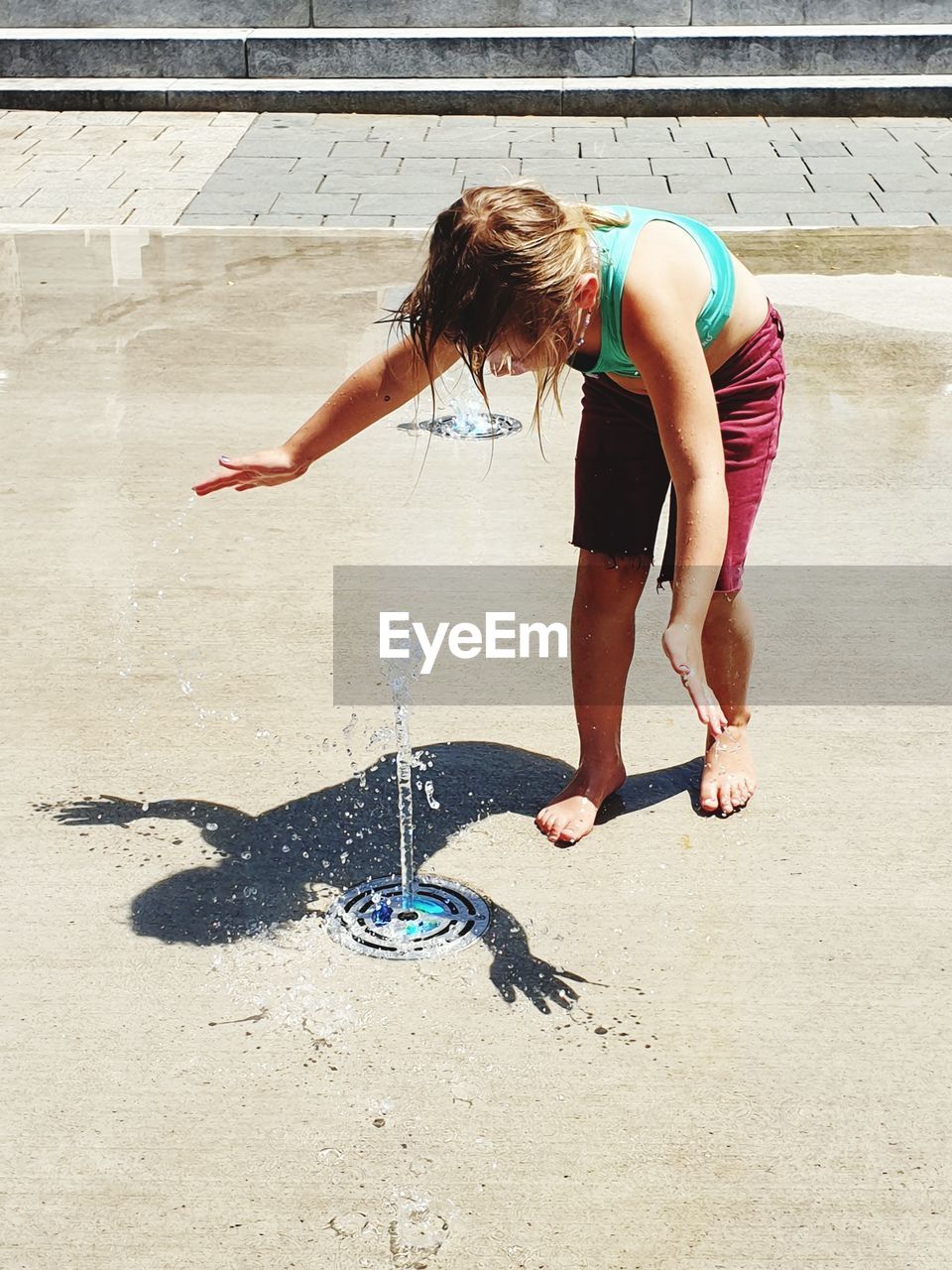 Playful girl at water fountain