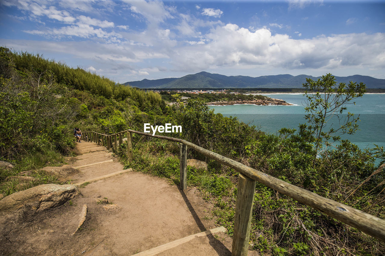 Scenic view of road by mountains against sky