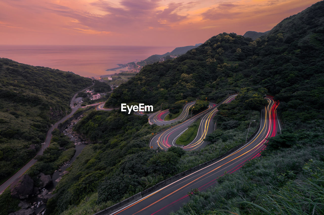 High angle view of light trails on road against sky during sunset