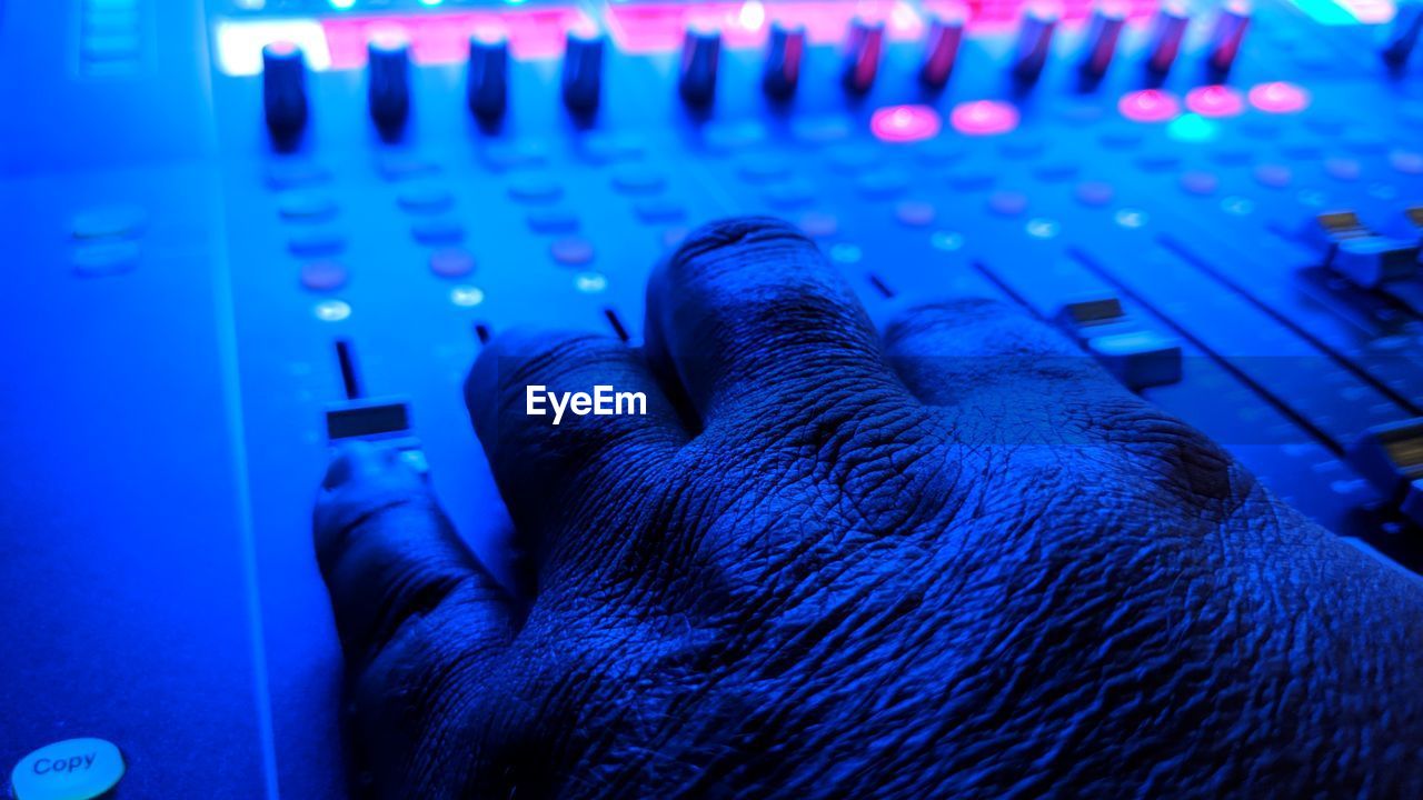 Cropped hand of mature man operating sound recording equipment