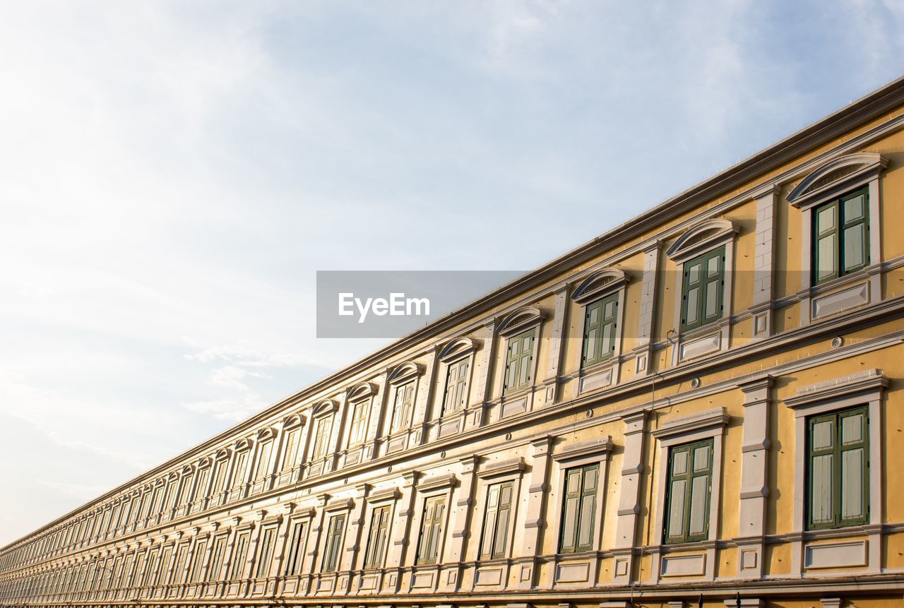 LOW ANGLE VIEW OF BUILDING AGAINST CLOUDY SKY