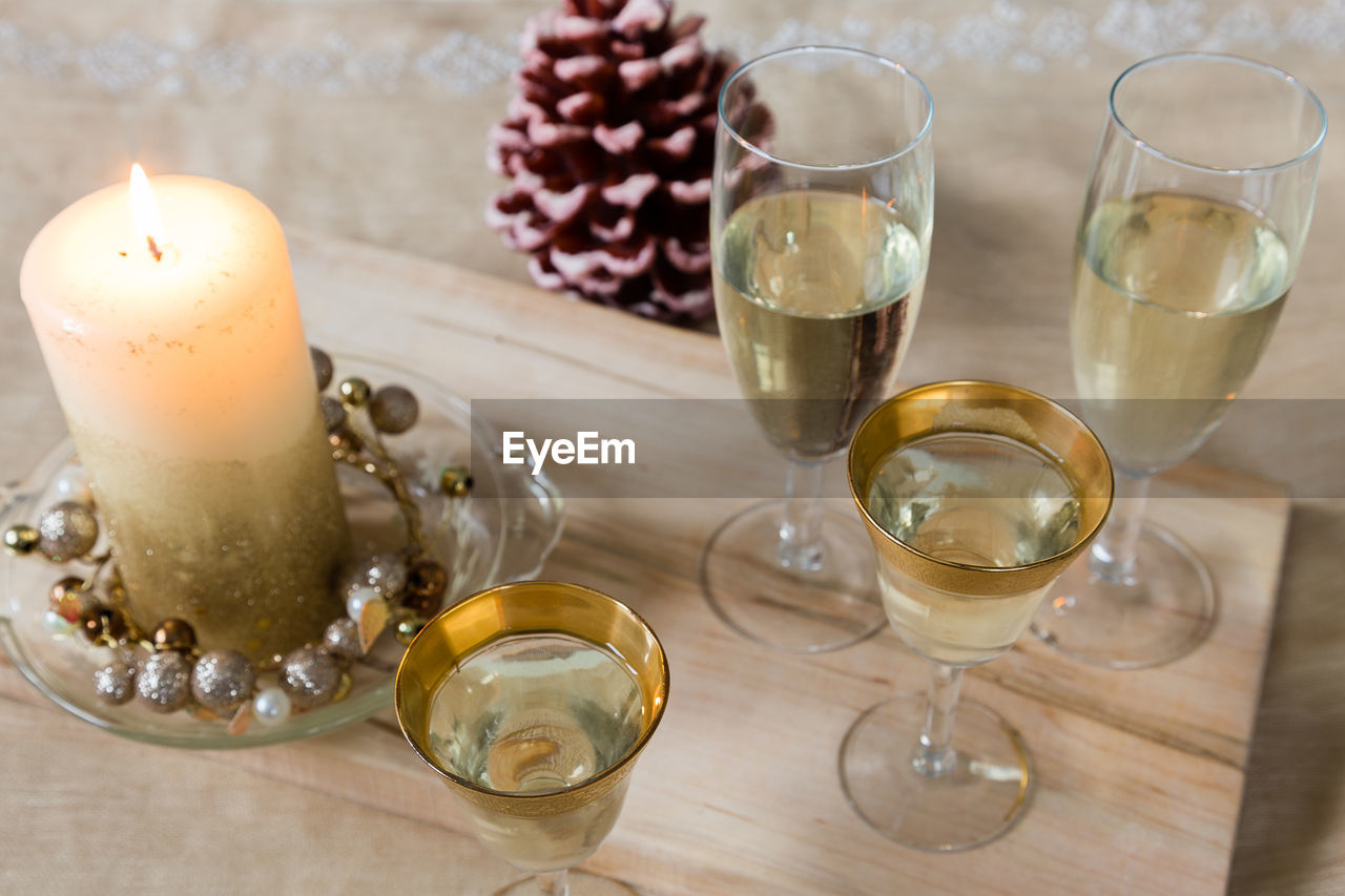 High angle view of table set with small gold-rimmed and tall glasses filled with white wine