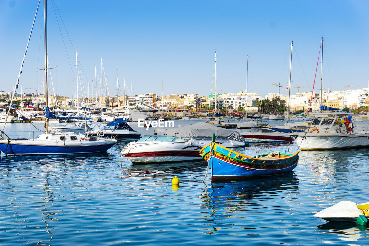 Boats moored in sea against sky