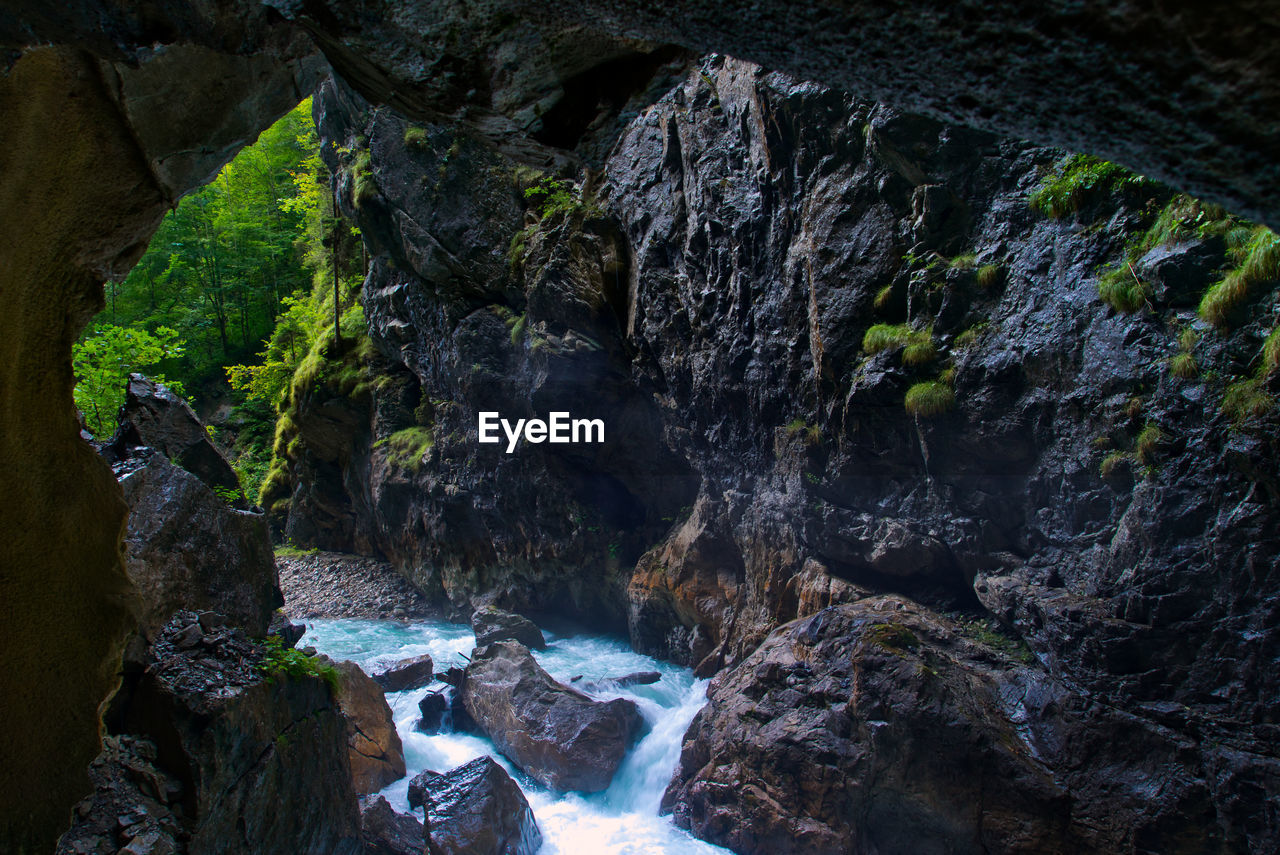 SCENIC VIEW OF WATERFALL IN MOUNTAINS