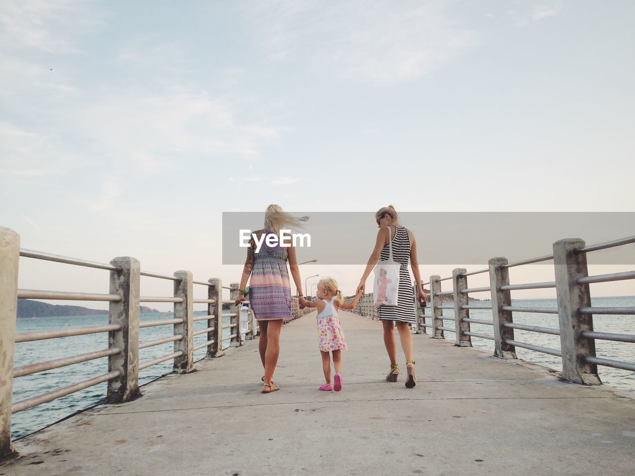 Rear view of women walking on jetty