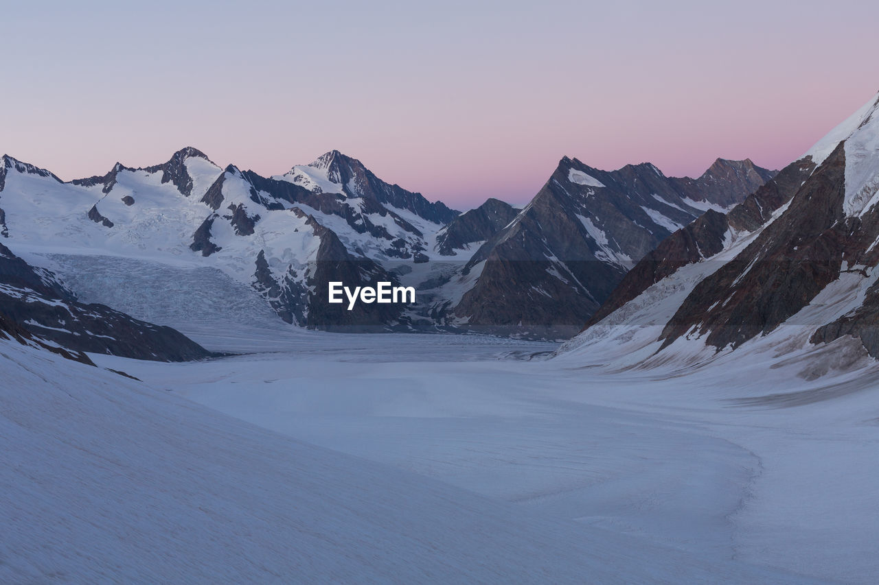 Scenic view of snowcapped mountains against clear sky during winter