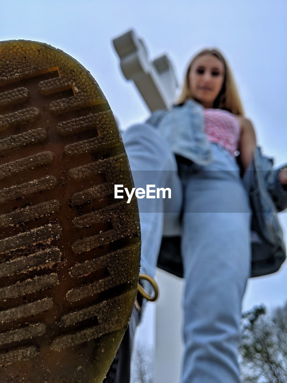 PORTRAIT OF YOUNG WOMAN STANDING BY METAL