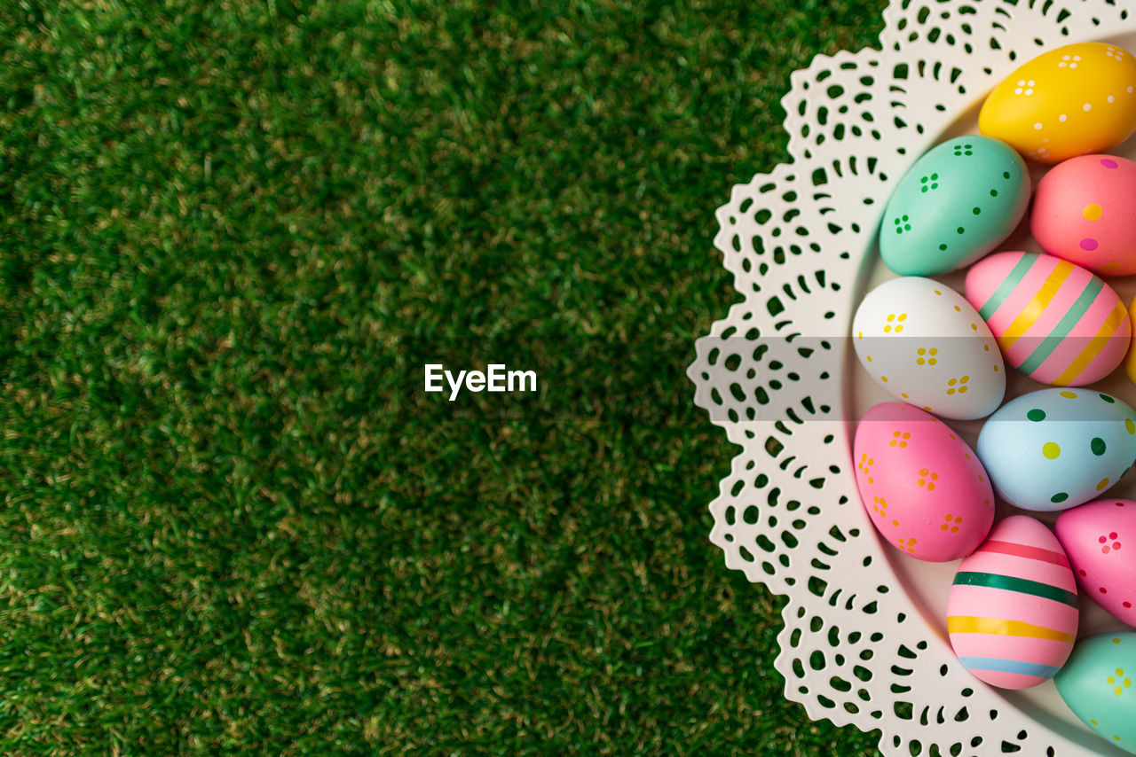 Easter header image with colorful painted pink, blue, yellow easter eggs and green grass. top view
