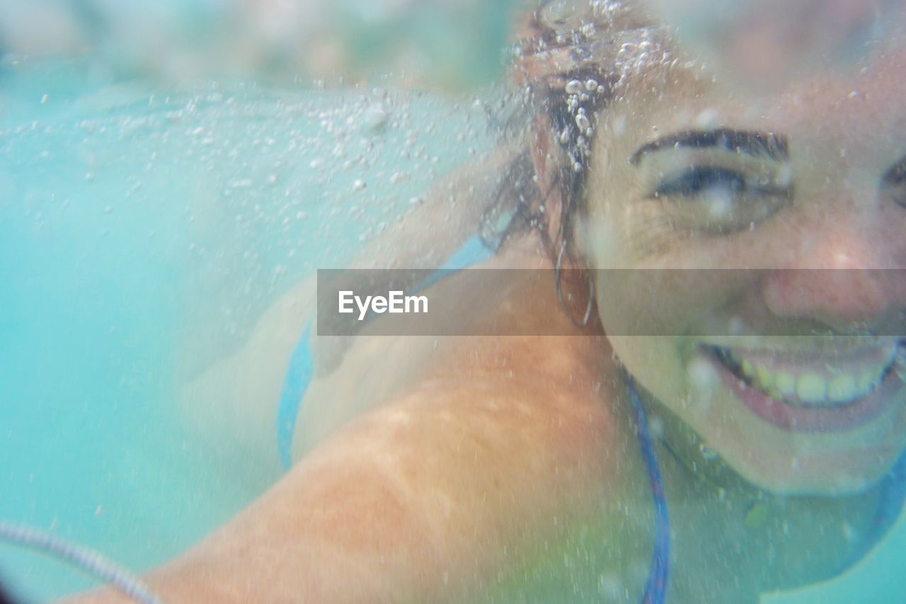 Close-up portrait of young woman swimming in pool