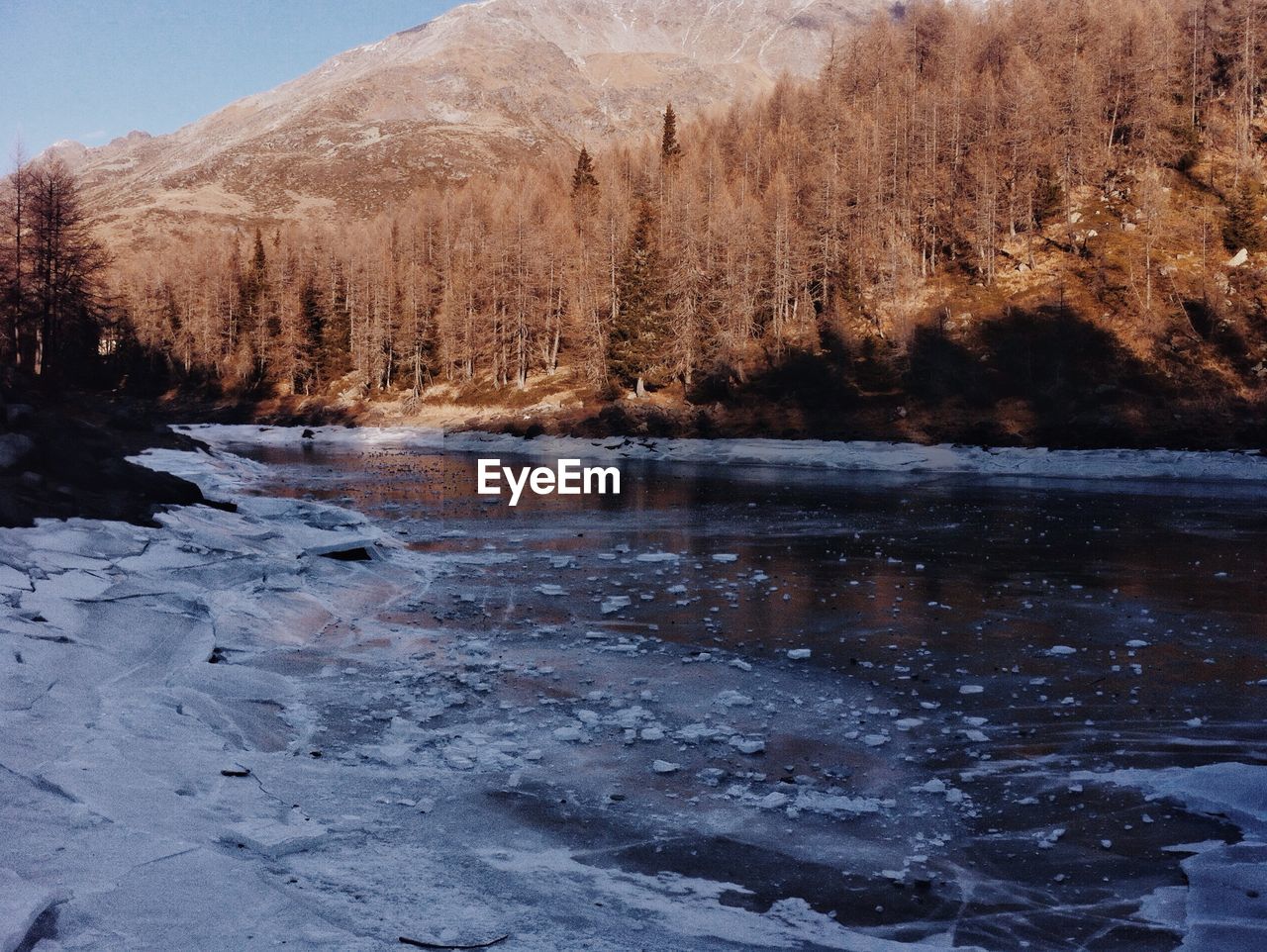 Scenic view of frozen lake by mountain