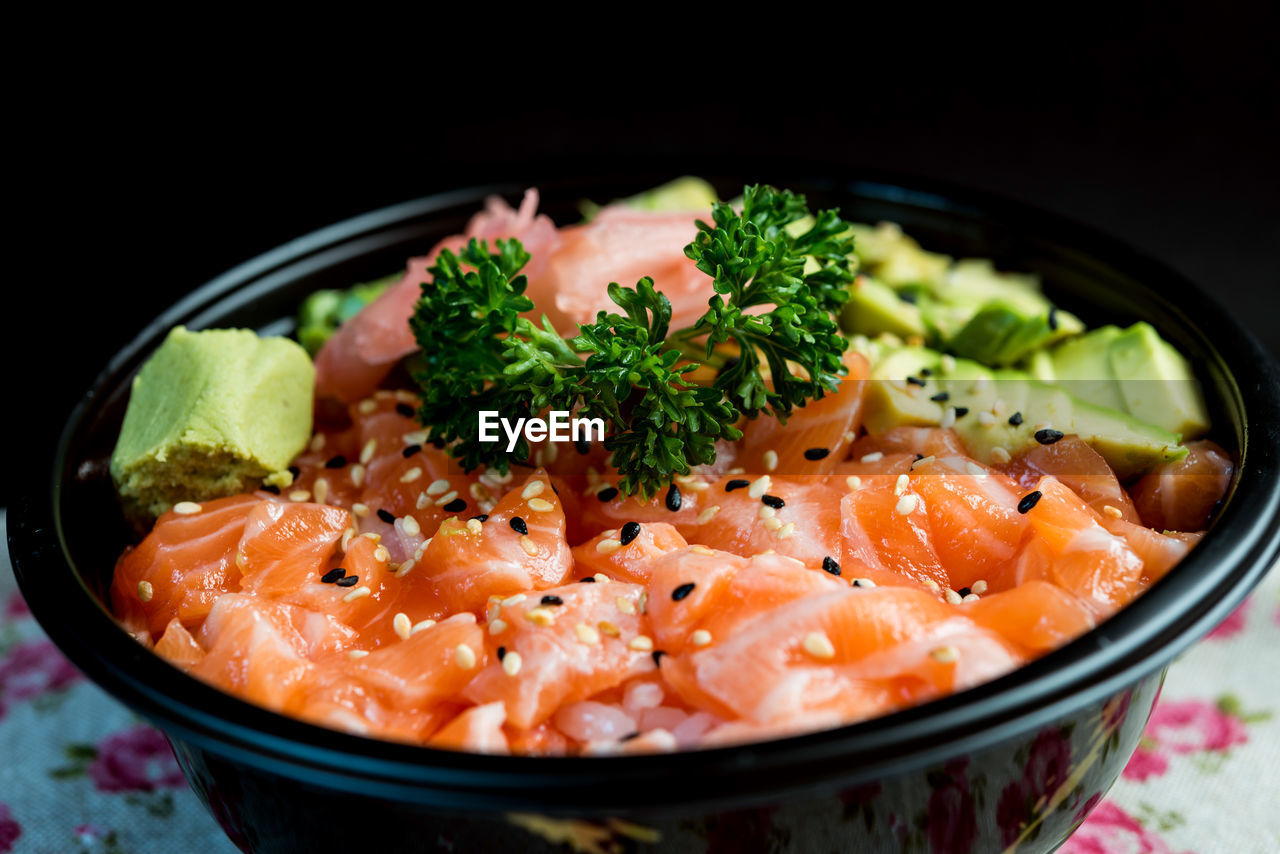 Close-up of chirashi in bowl on table against black background