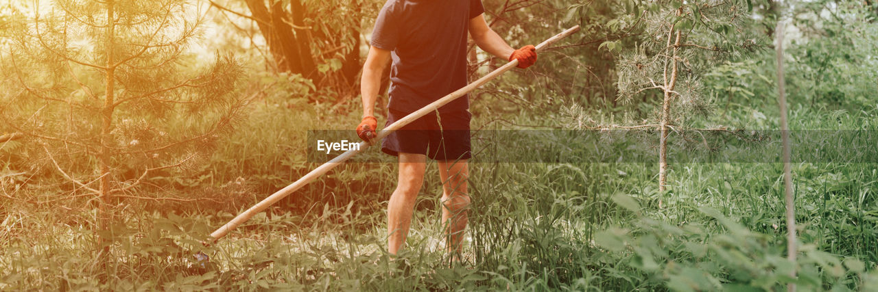 Mowing grass with hand scythe on household farm. farmer man mowing weed of farmland with scythe.