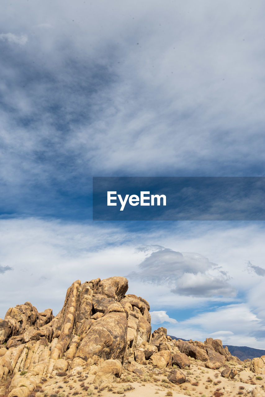 Low angle view of rock formation against sky filled with cloud formations