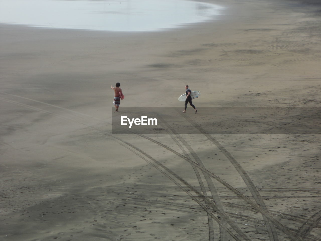 PEOPLE WALKING ON SANDY BEACH