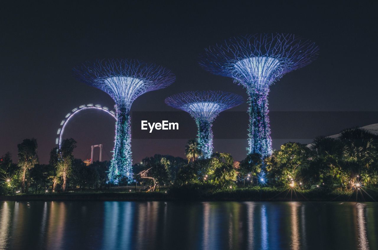 ILLUMINATED BRIDGE OVER RIVER AGAINST SKY