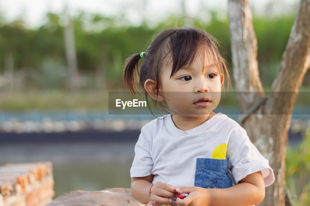 Portrait of cute girl looking away outdoors