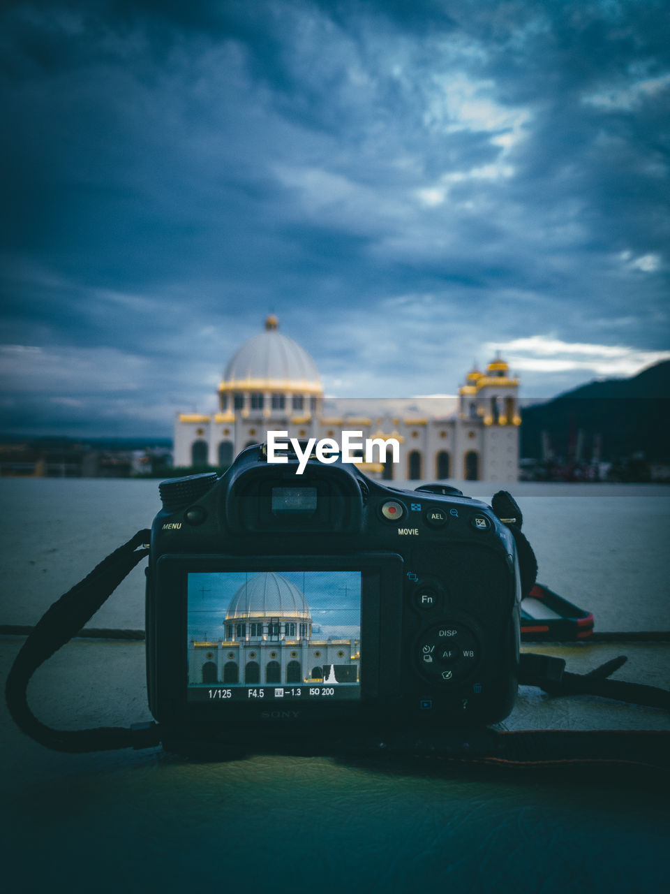 Cámara forografica en paisaje de atardecer con catedral de san salvador en un cielo azul