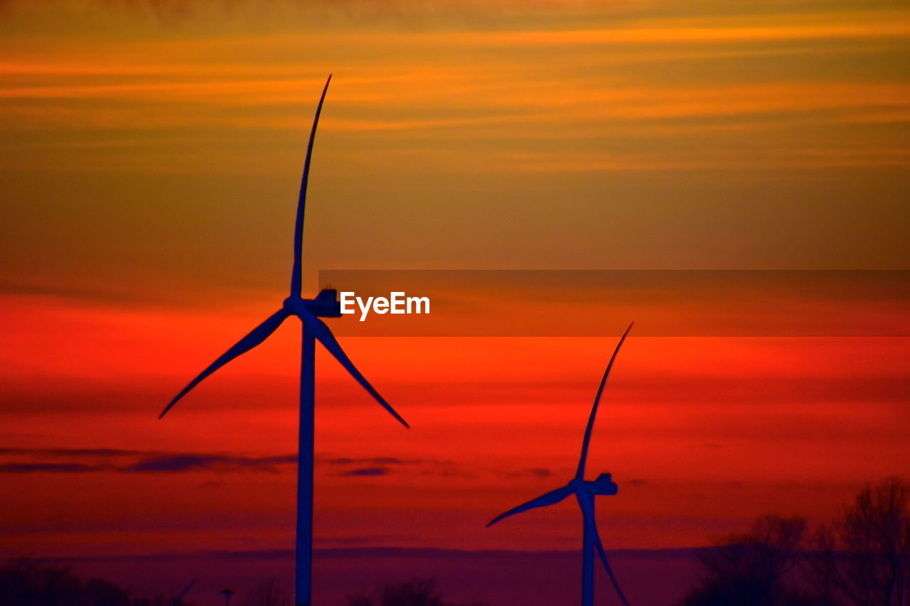 Scenic view of sunset with two windmills