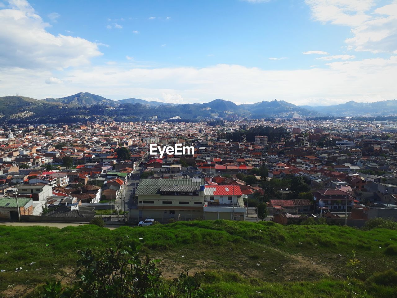 HIGH ANGLE VIEW OF TOWN AGAINST MOUNTAINS