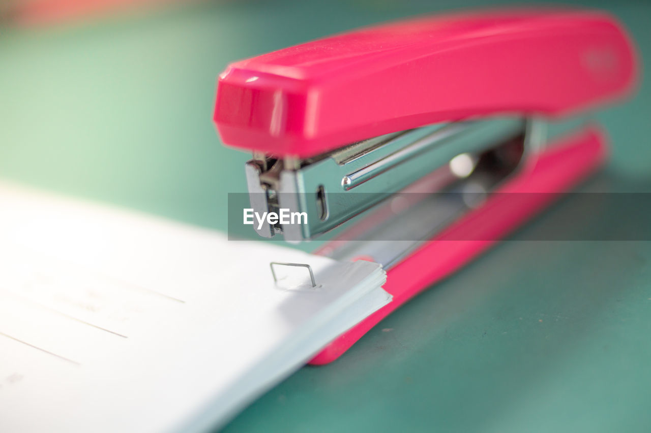 Close-up of stapler and papers on table