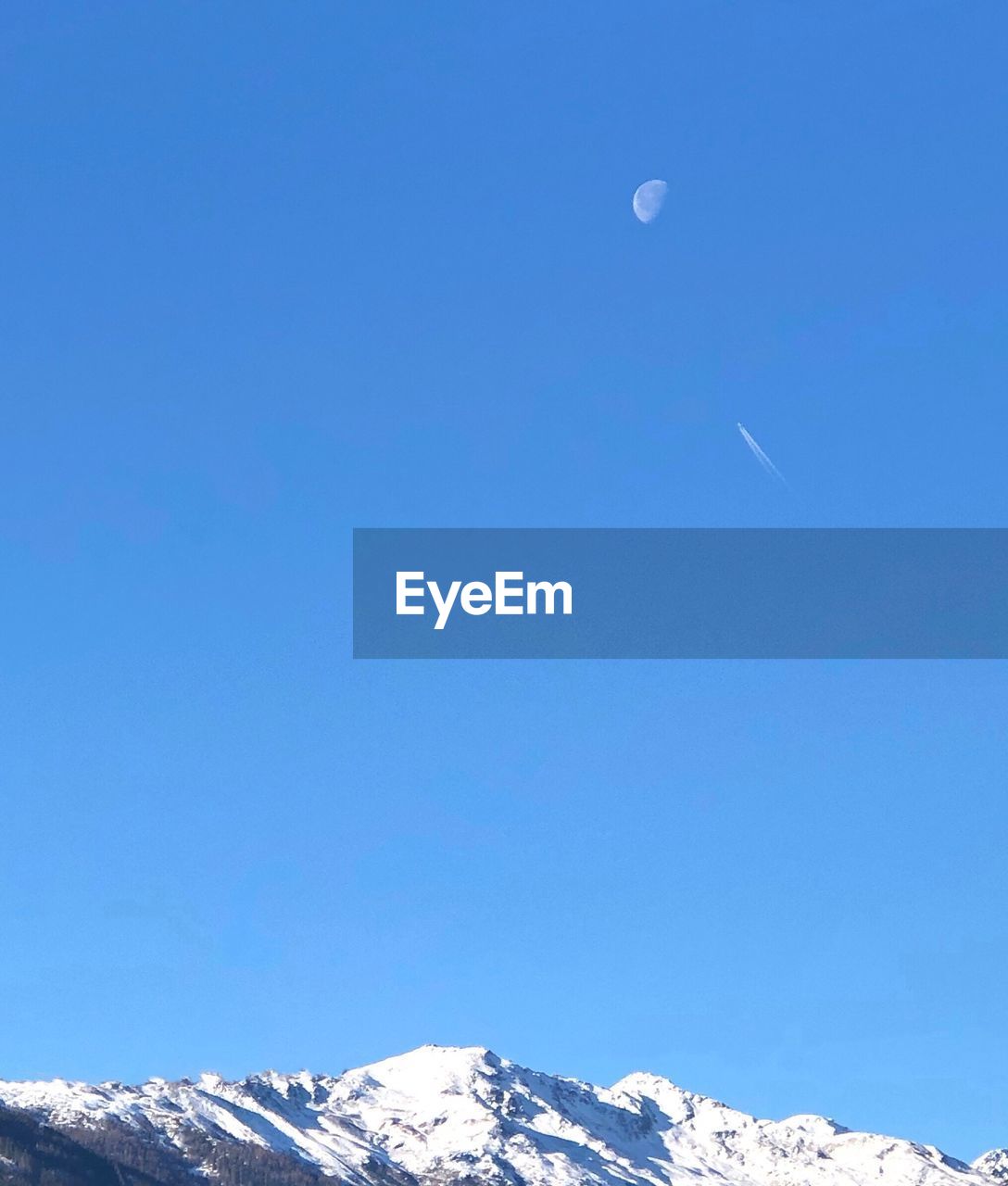 LOW ANGLE VIEW OF SNOWCAPPED MOUNTAINS AGAINST CLEAR BLUE SKY