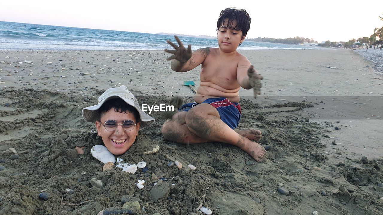 Boys playing with sand at the beach 