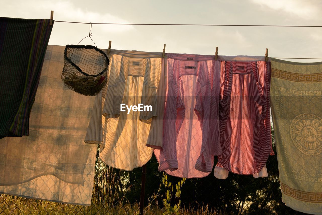 Low angle view of laundry drying on clothesline against sky