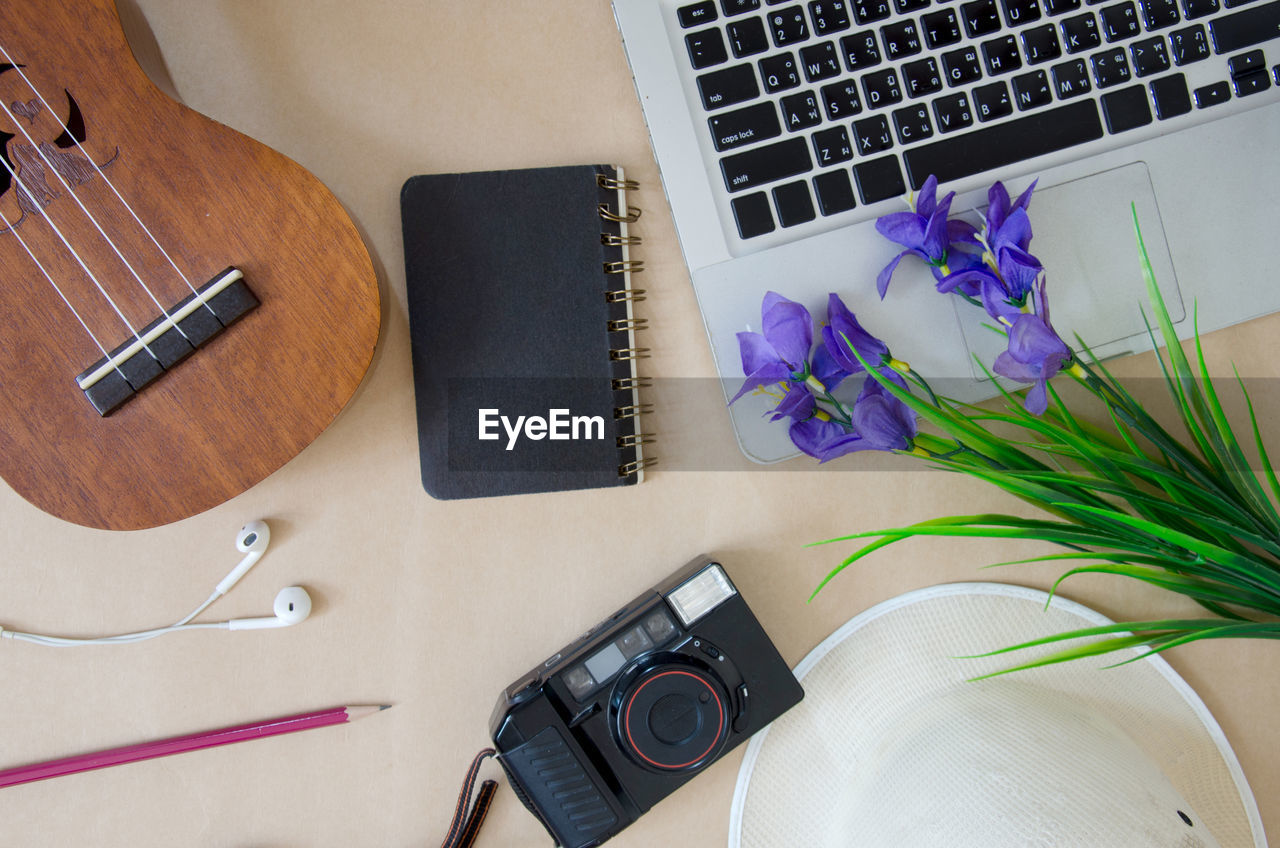 Directly above shot of personal accessories with fresh flowers on table