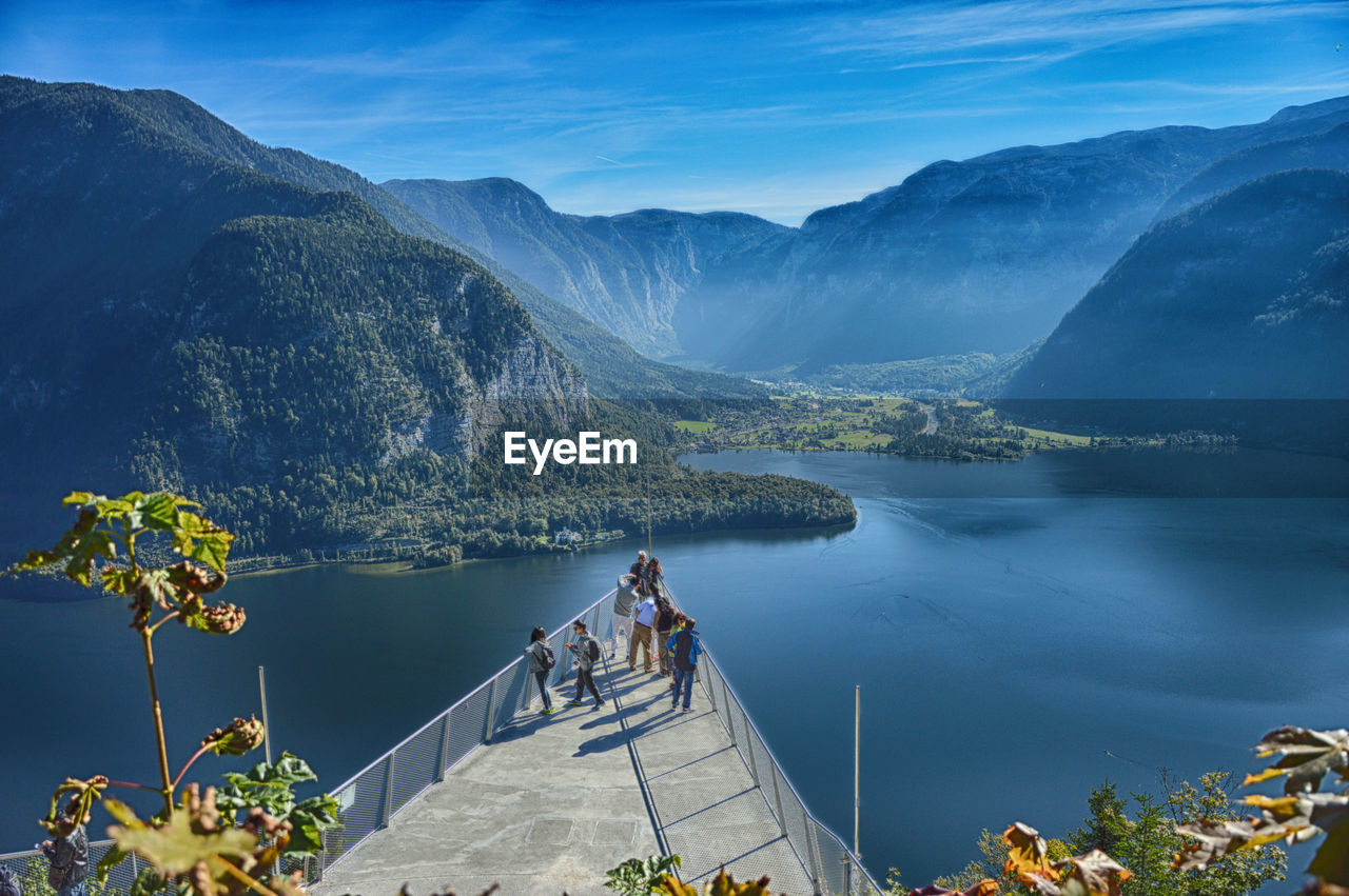 High angle view of people at observation point over lake against mountains