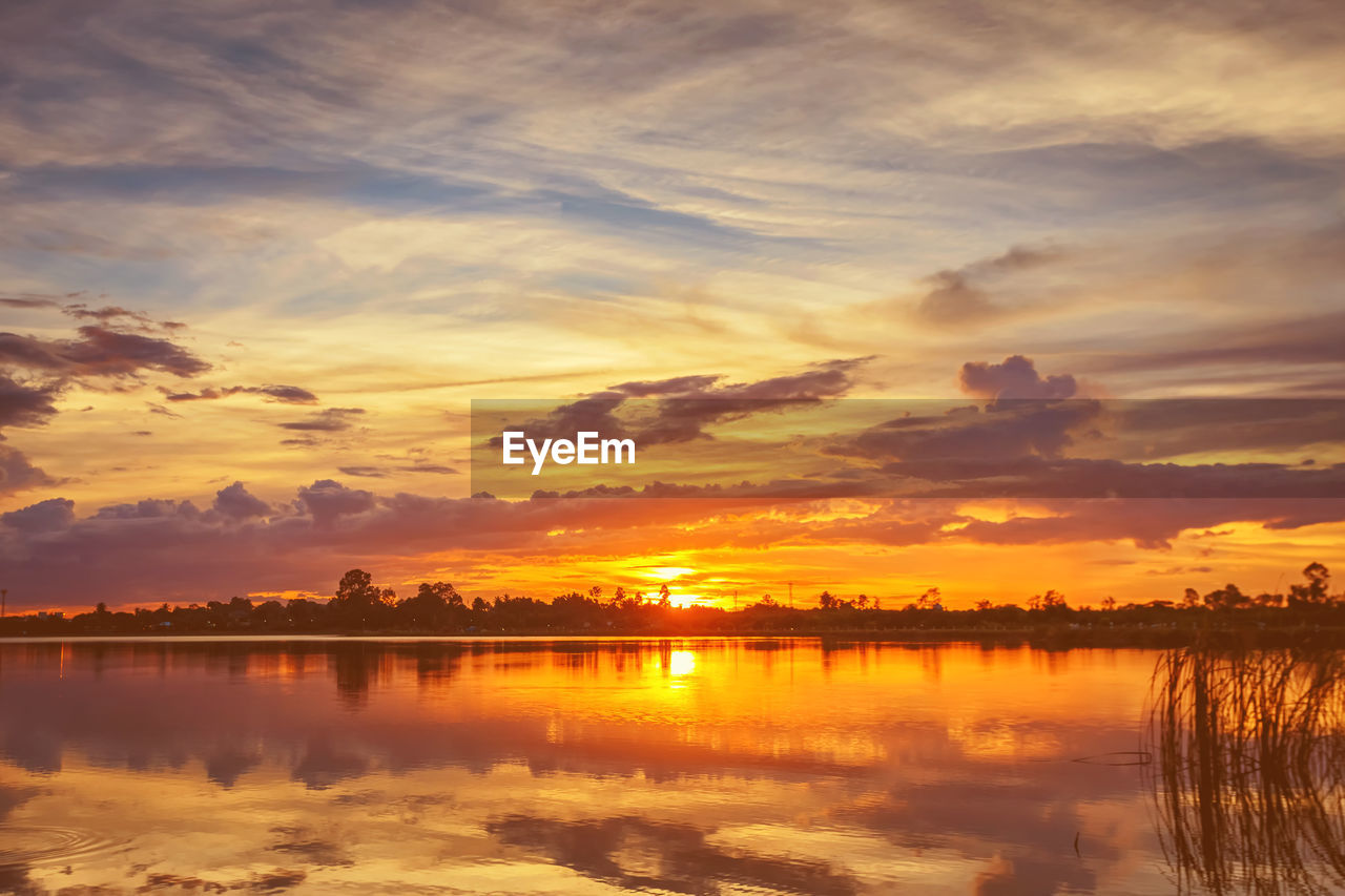 SCENIC VIEW OF LAKE AGAINST SKY AT SUNSET