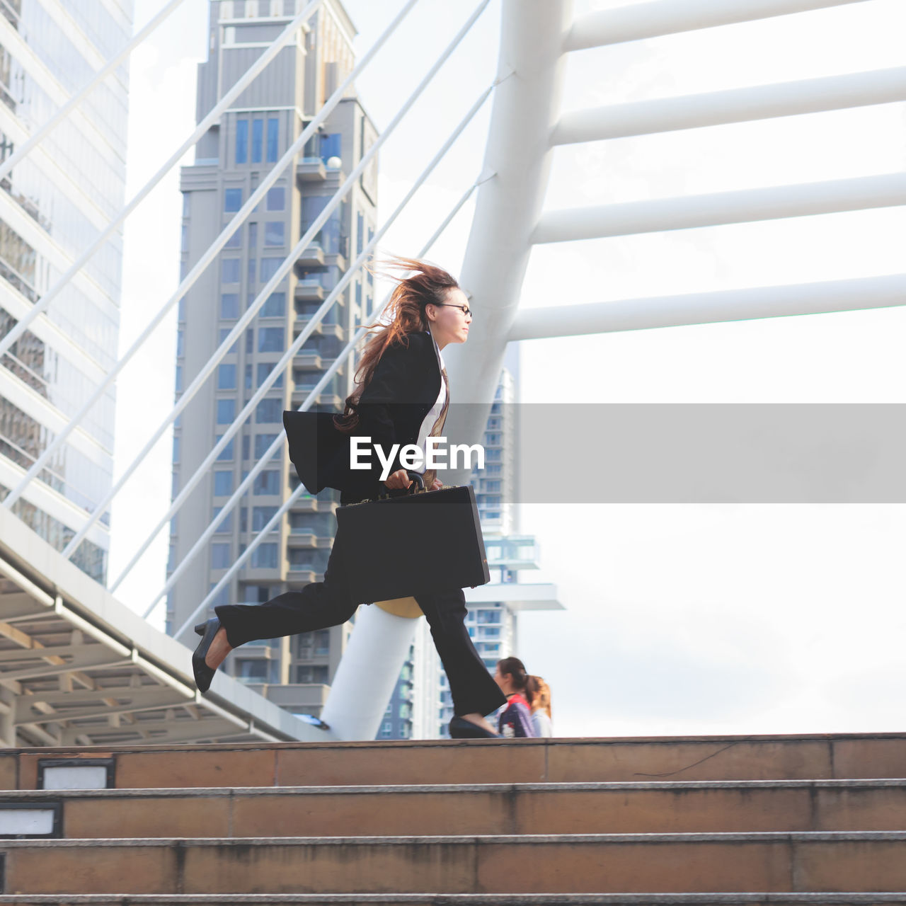 Low angle view of woman running on staircase in city