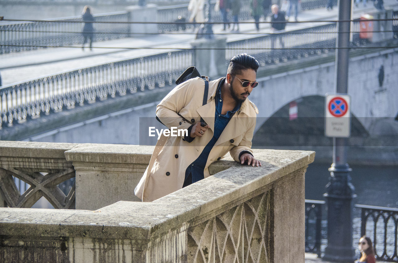 Young man looking down at bridge