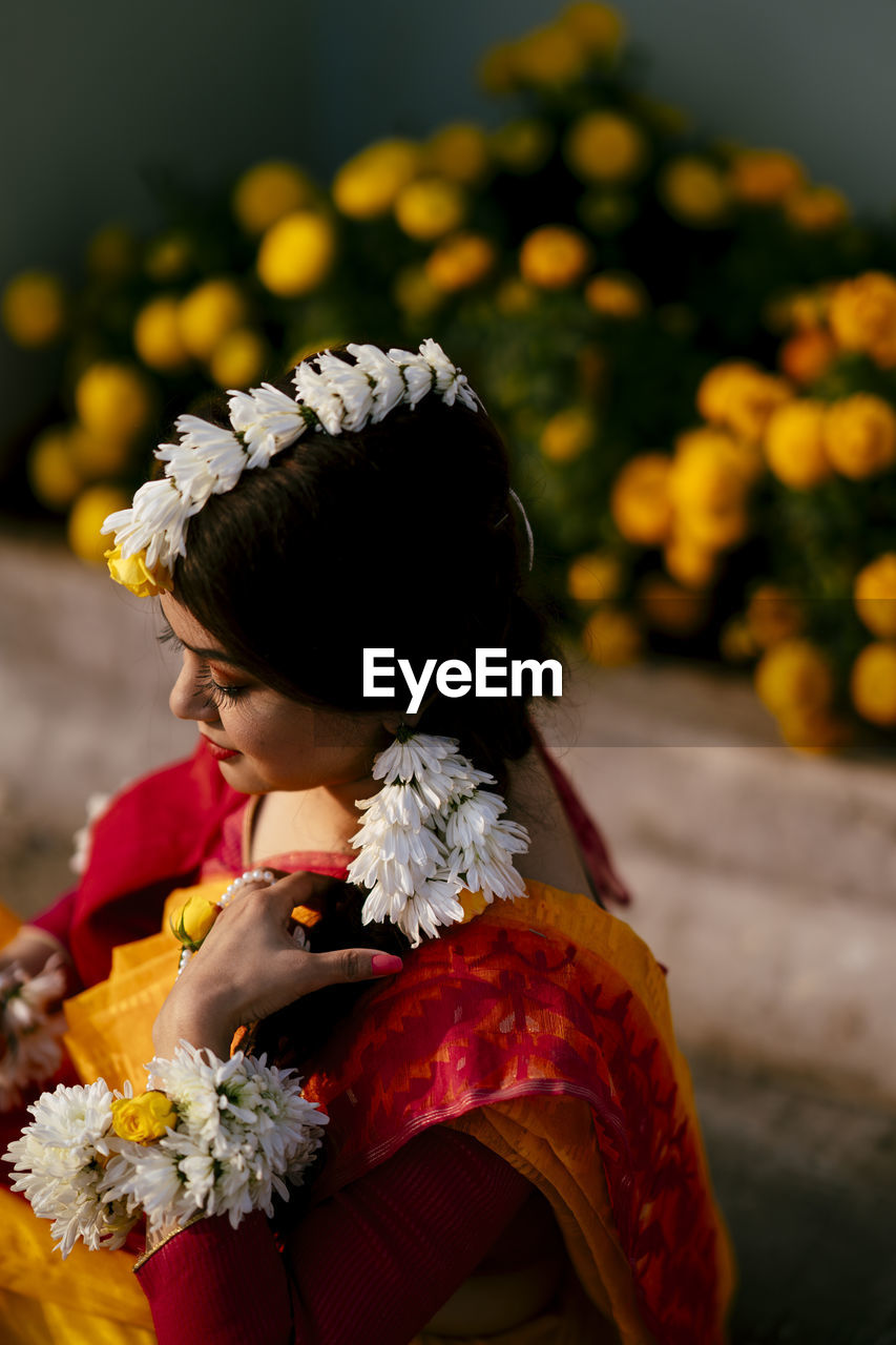 High angle view of bride wearing flowers while standing outdoors