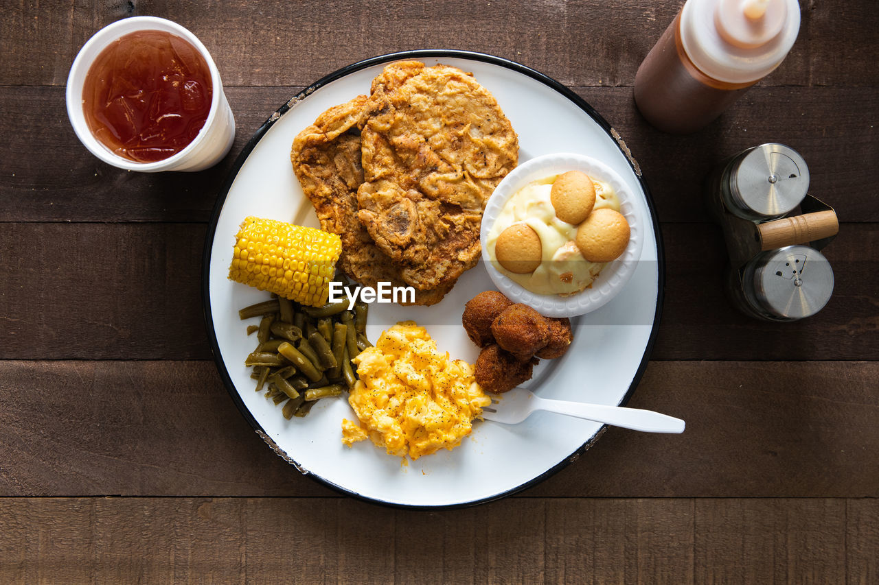 Pork chop plate and sweet tea on a rustic wood table