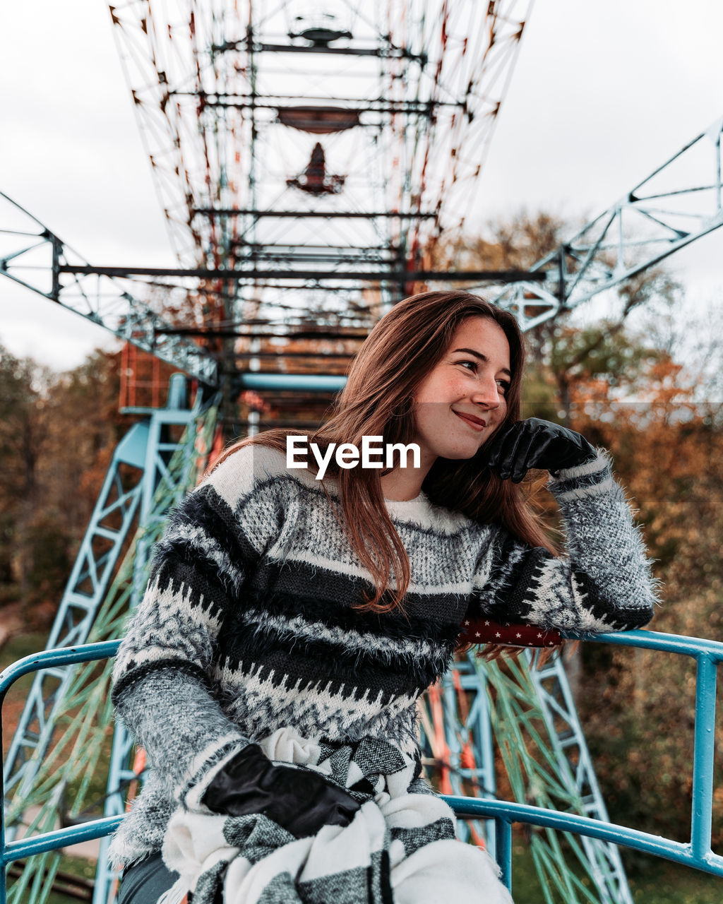 Smiling young woman sitting on ferris wheel