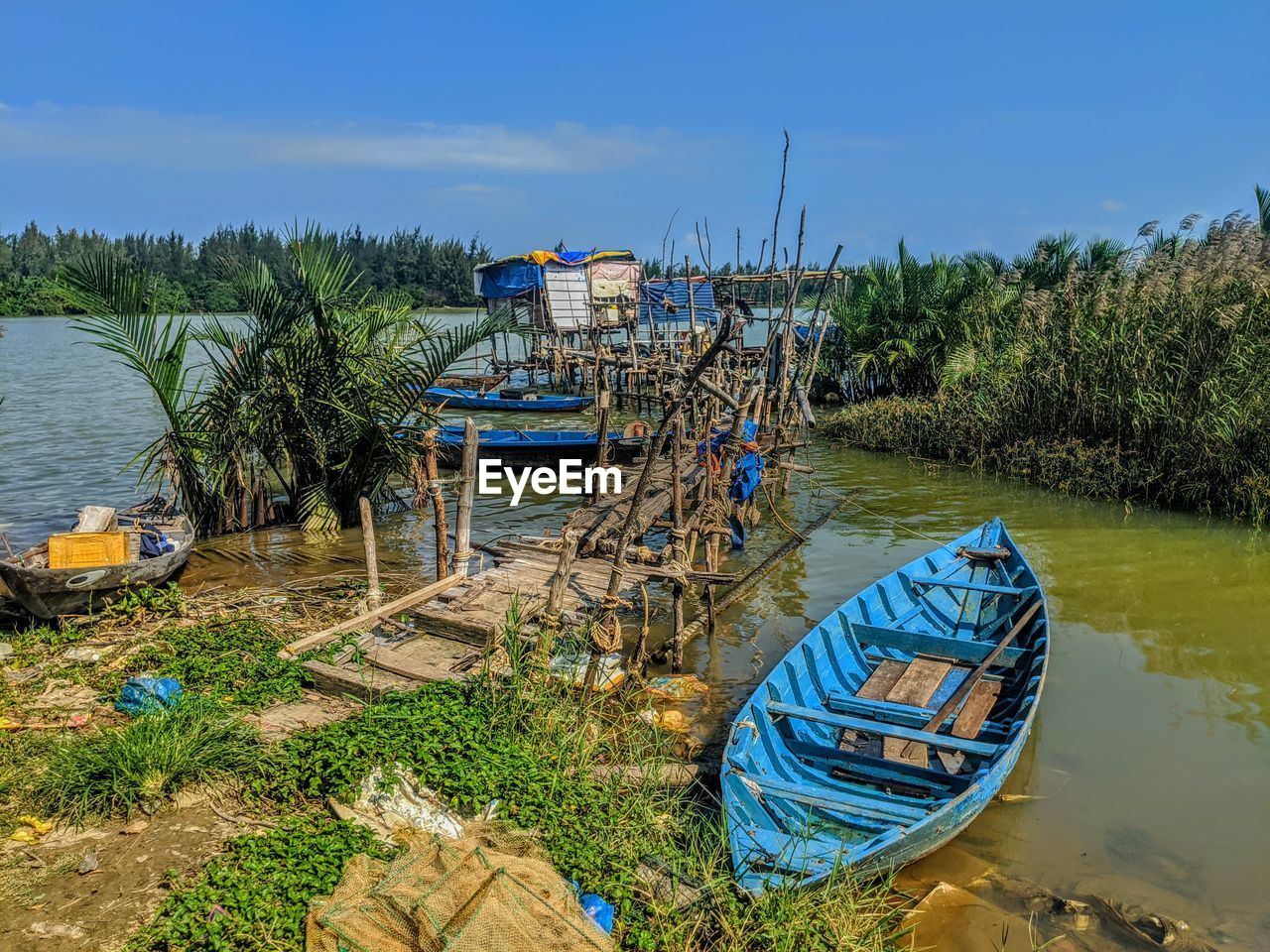 Fishing boats moored on sea against sky