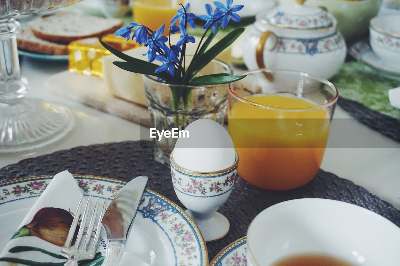 High angle view of boiled egg and juice served on dining table