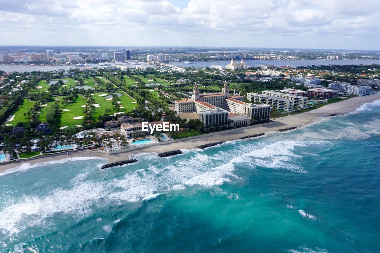 Aerial view of city by lake worth inlet against sky