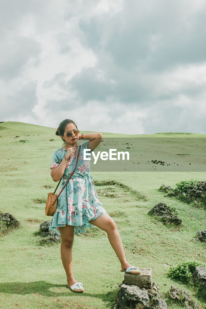 Full length of woman standing on land against sky