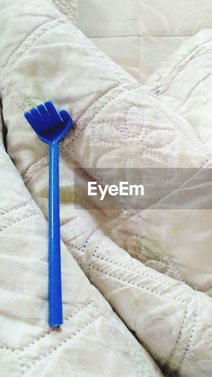 HIGH ANGLE VIEW OF UMBRELLA ON BED IN HOME