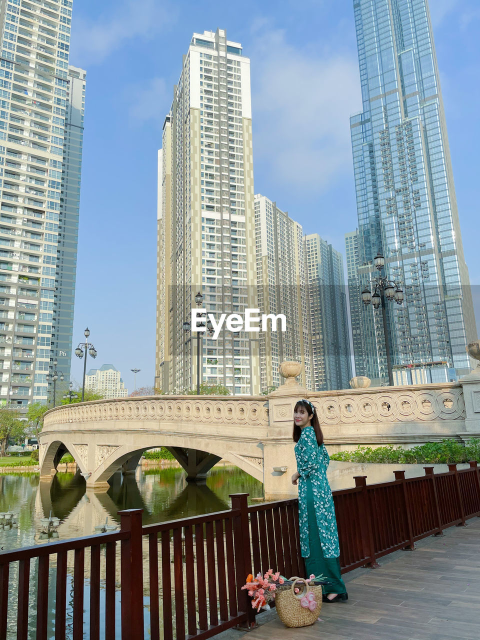 Woman standing by modern buildings against sky