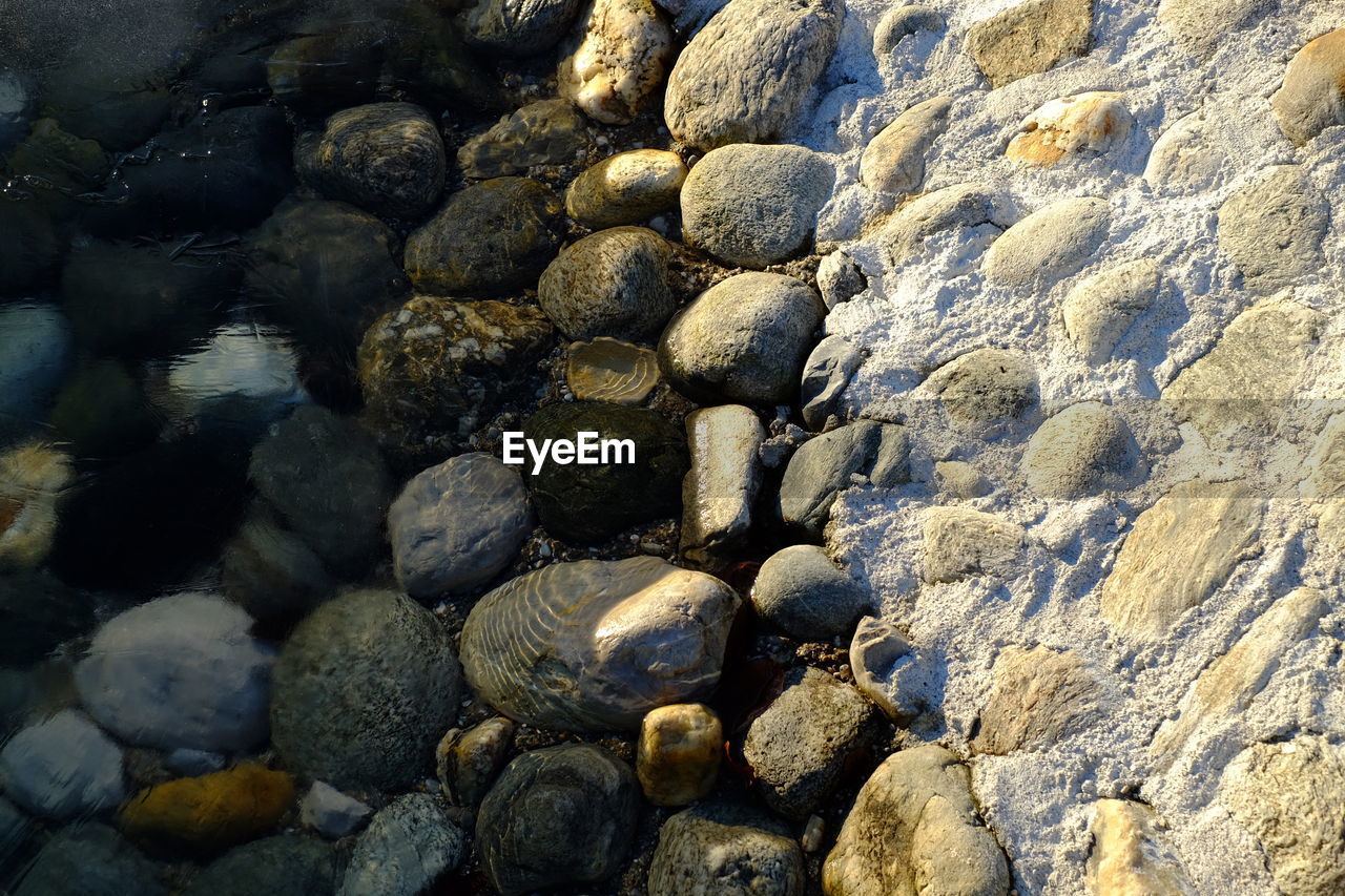 FULL FRAME SHOT OF STONES ON SHORE