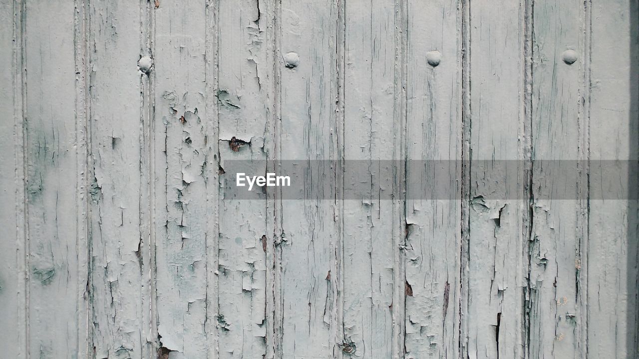 Full frame shot of withered white painted wood wall panels.