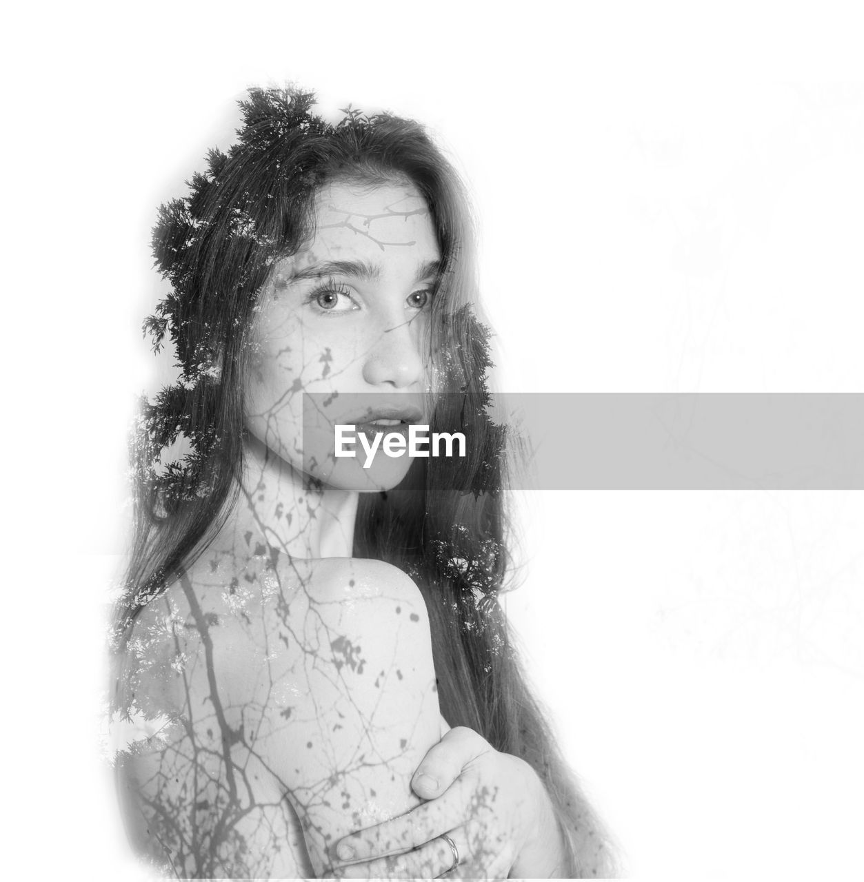 Double exposure of shirtless woman and trees against white background