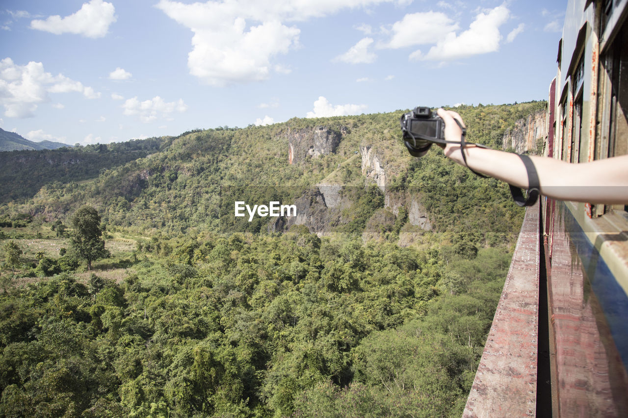 Hand holding a camera over iconic gokteik viaduct, myanmar