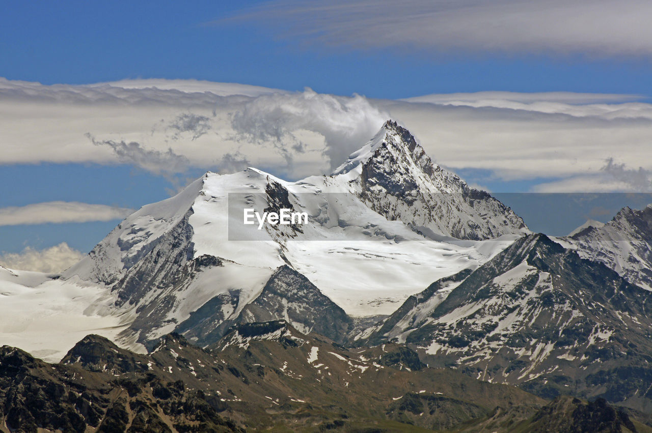 Scenic view of mountains against cloudy sky