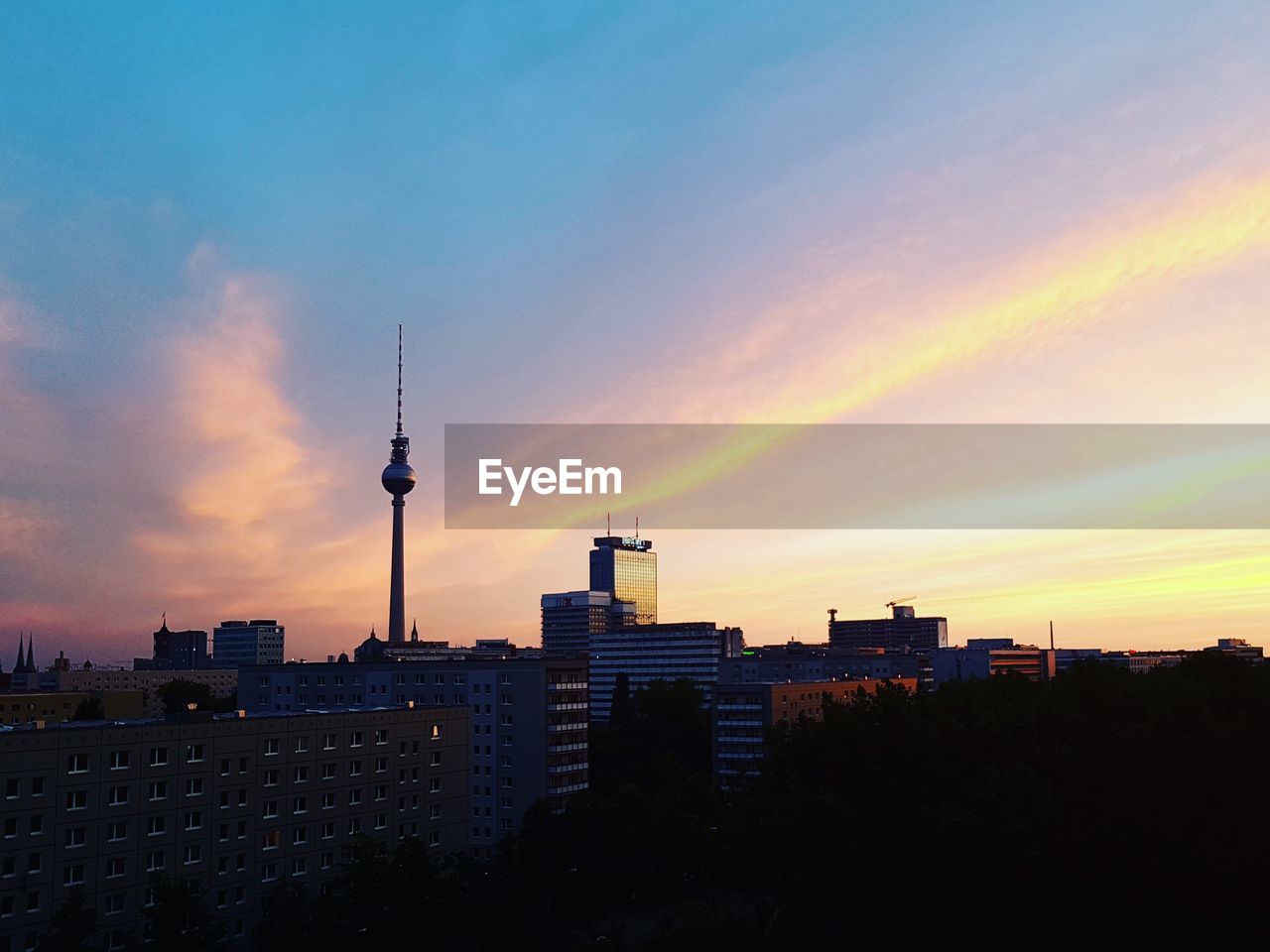 Buildings in city against sky during sunset