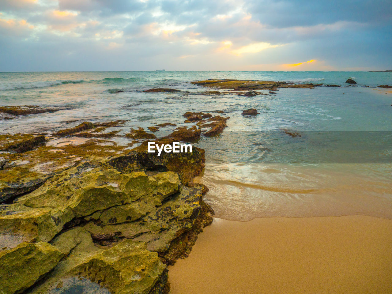 Scenic view of beach against sky during sunset