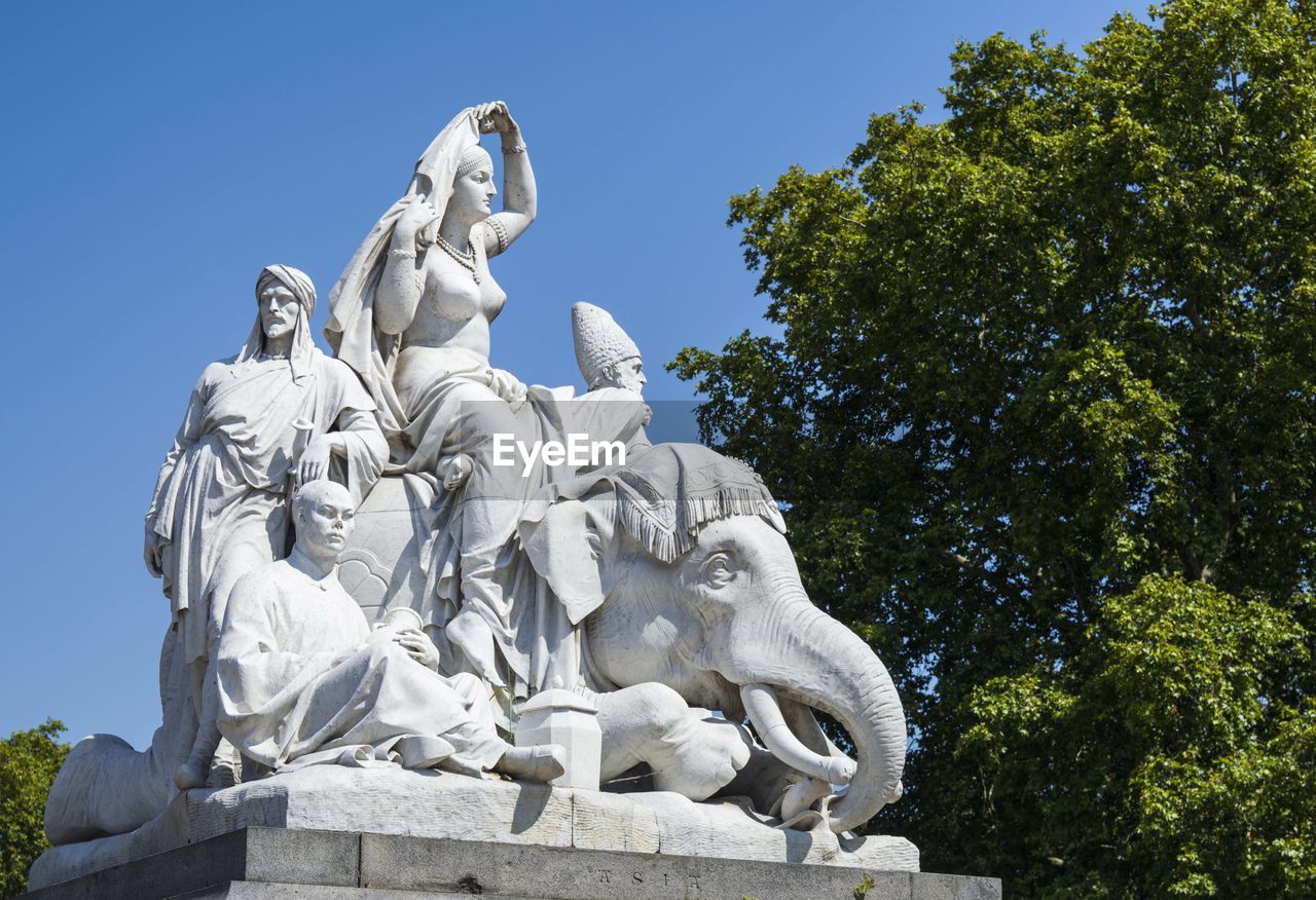 LOW ANGLE VIEW OF STATUE AGAINST TREES AGAINST SKY